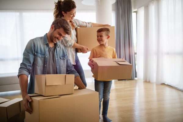 Happy family unpacking boxes in new home on moving day