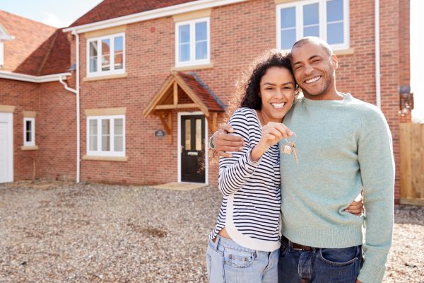 Retrato de una pareja con las llaves en la puerta de su nueva casa el día de la mudanza