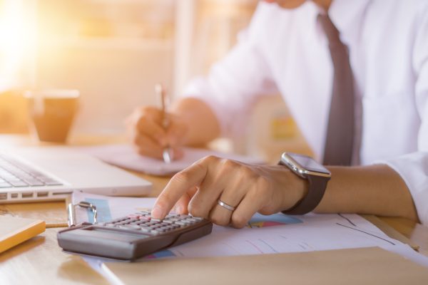 Businessman accountant using calculator and laptop for calculating finance on desk office. business financial accounting concept.