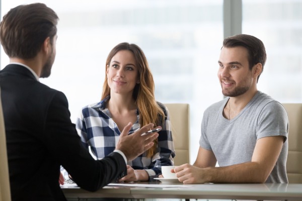 Pareja de clientes consultando a un agente inmobiliario, abogado o asegurador sobre la compra de una casa o servicios de seguros, vendedor, empleado de banco o asesor financiero haciendo una oferta de presentación a los clientes en una reunión en la oficina.