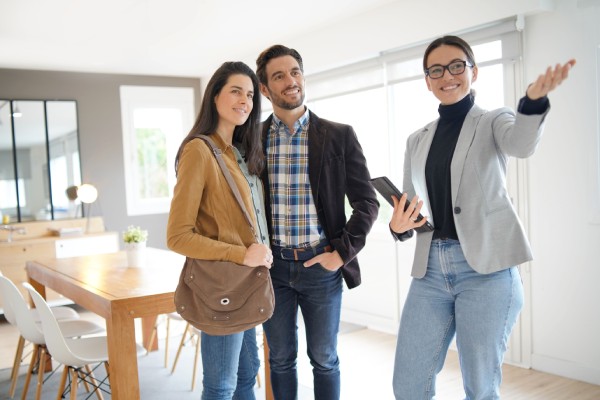 Real estate agent showing modern house to attractive couple
