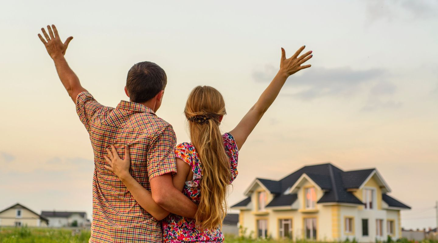 a happy couple looking at their home