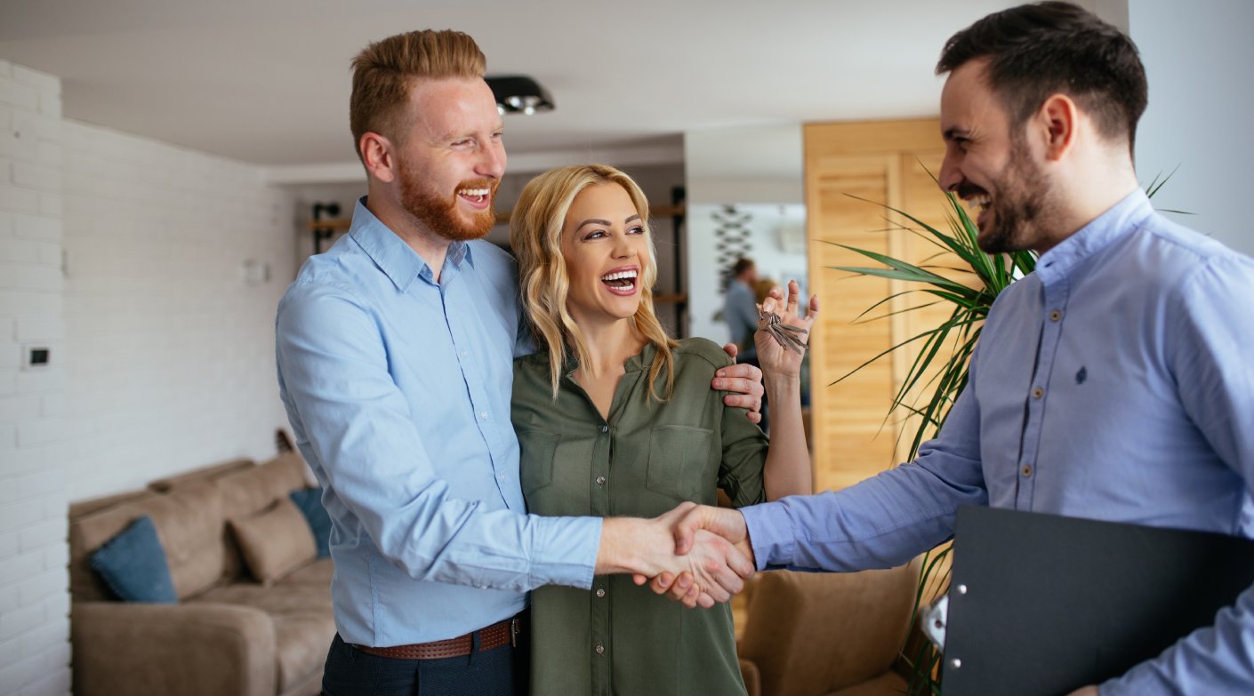 Portrait of financial adviser congratulating to a young couple for buying a new house.
