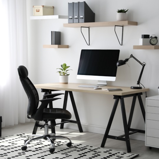 Comfortable office chair near table with modern computer