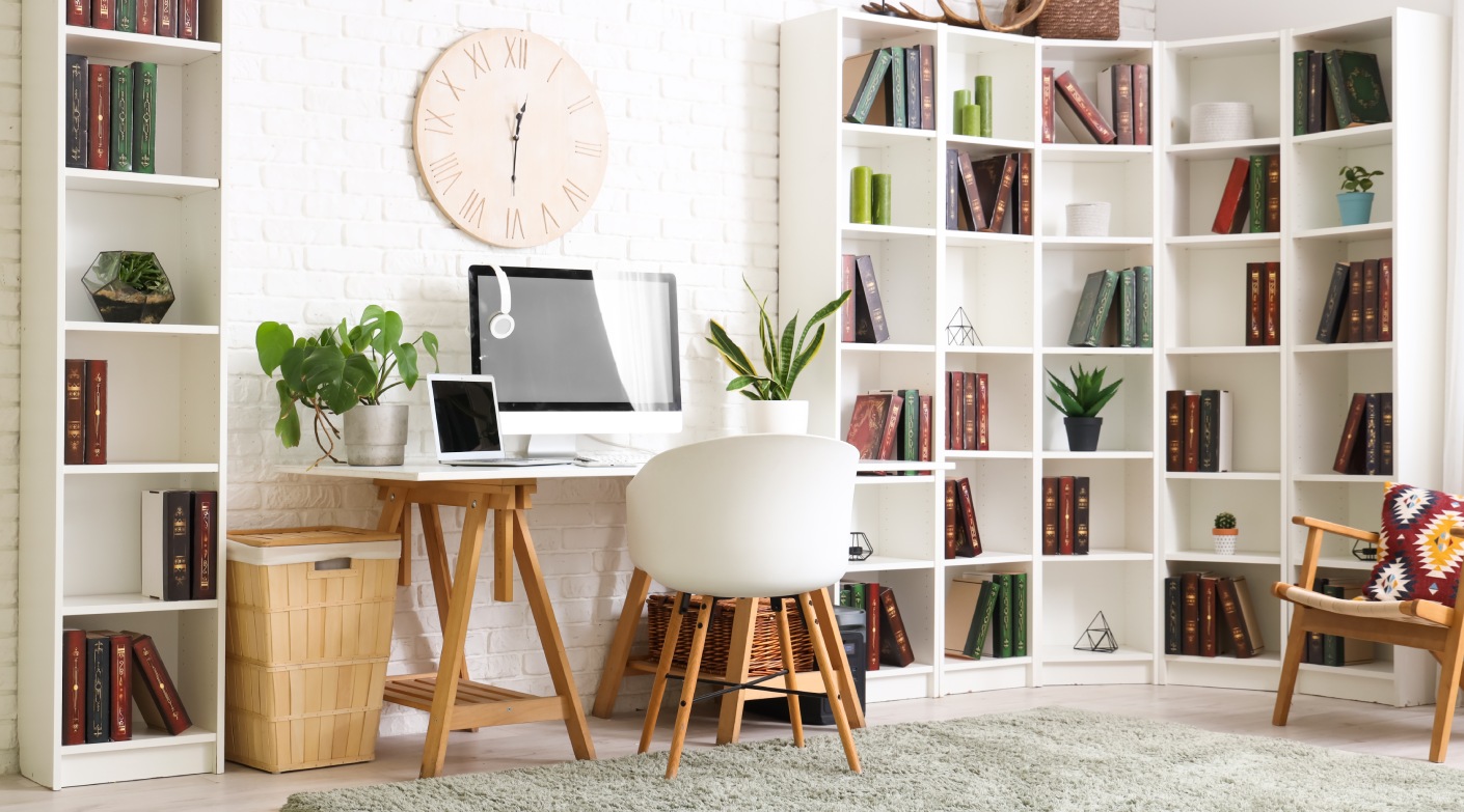 Stylish office with workplace, modern computer, chair and bookcase