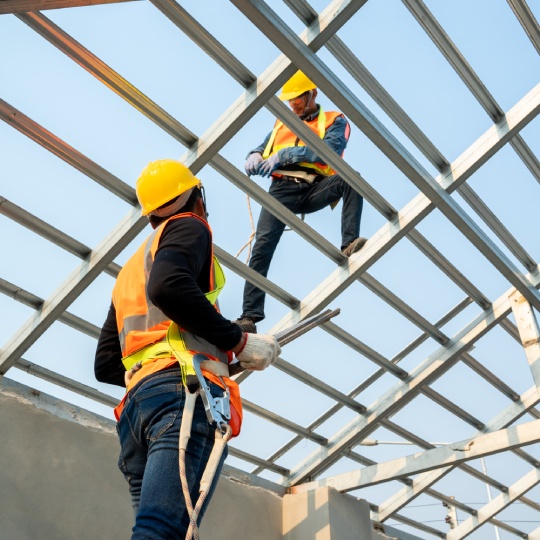 Roofer builder worker attach metal sheet to new roof on top roof,Unfinished roof construction.