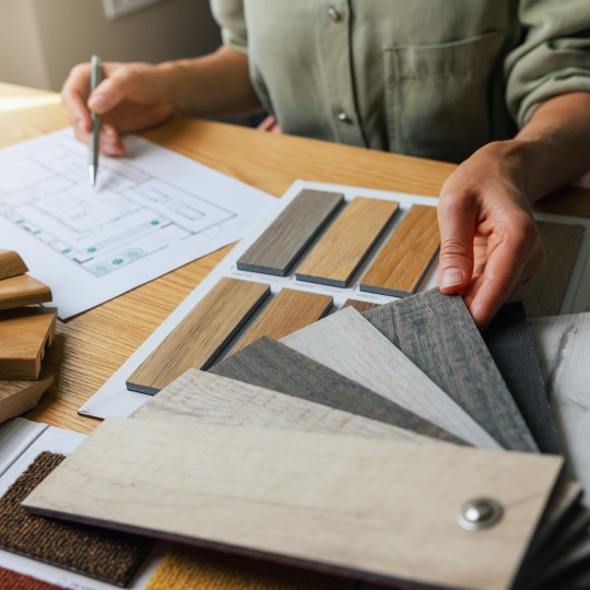 interior designer working on new house design project in office. choosing flooring and furniture materials and colors from samples