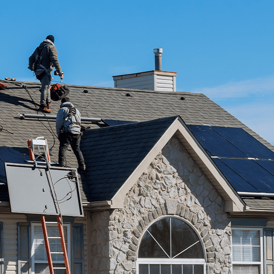 Roofers installing solar panels.