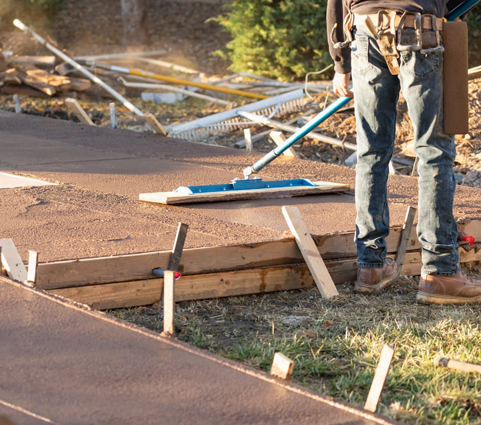 A man works on a concrete driveway as part of a commercial construction project in McAllen.