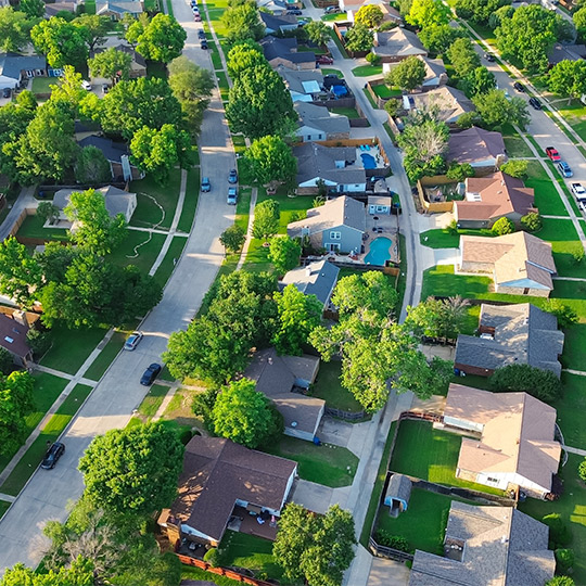 Aerial view of a suburban neighborhood in Texas, showcasing houses and trees, highlighting the 2025 RGV housing market insights.