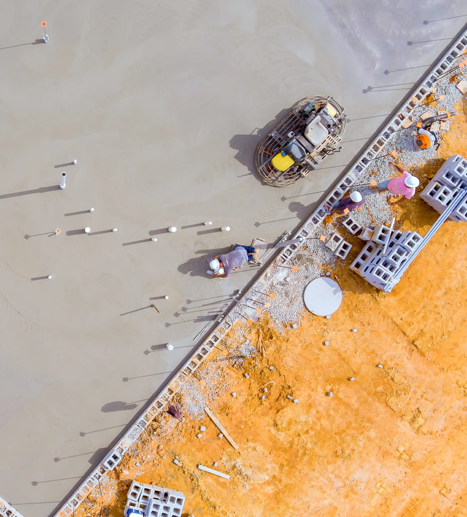 Overhead view of a construction site with machinery, highlighting concrete work by Liongate Builders in McAllen, South Texas.