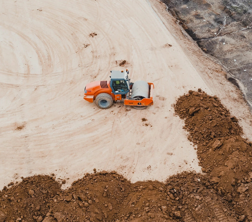 A bulldozer is actively working on a dirt road for a commercial construction project in McAllen.