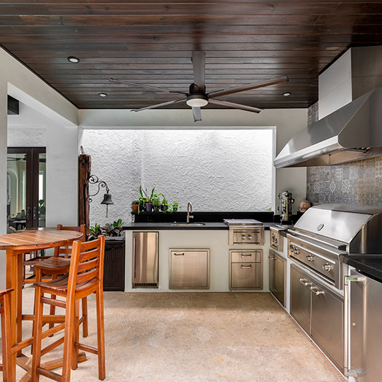  A bright kitchen featuring a ceiling fan and a dining table, perfect for summer gatherings in your custom home.