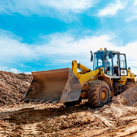 A bulldozer drives across a field, illustrating McAllen's excavation needs in flood-prone regions.