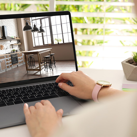 A first-time home buyer in South Texas uses a laptop to explore kitchen designs and layouts.