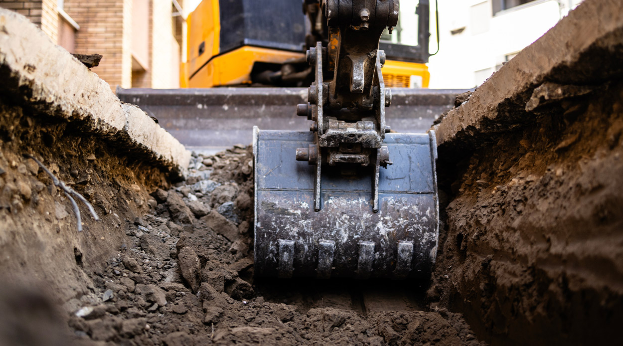 A construction machine digging into the earth, showcasing the efficiency of excavation services for McAllen businesses.