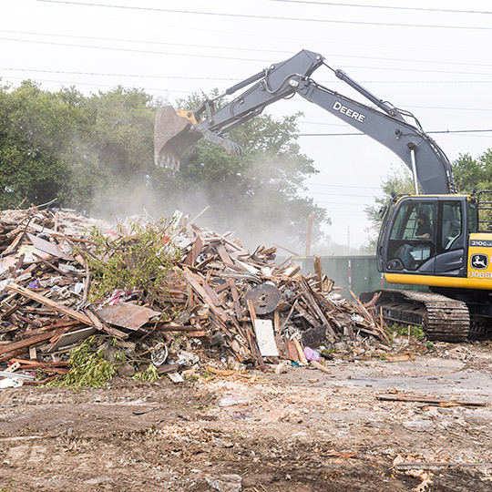 A bulldozer operates on a rubble pile, illustrating time-saving excavation methods for McAllen businesses.