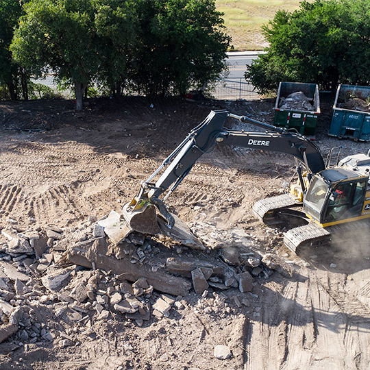 A bulldozer operates on a rubble pile, illustrating how McAllen businesses enhance efficiency through excavation.