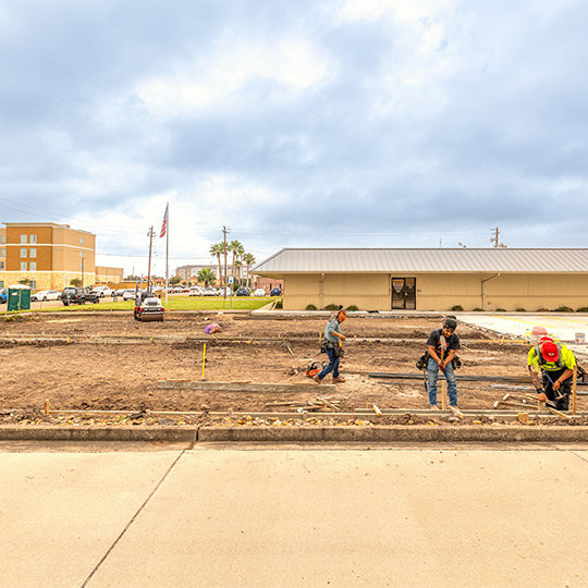 A diverse group of workers collaborating on a construction site, wearing safety gear and using tools. Construction