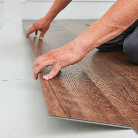 A man reclines on a wooden floor, reflecting a casual moment in a setting about tenant improvements in McAllen.